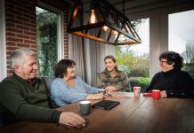 Familie rondom de eettafel met elkaar in gesprek