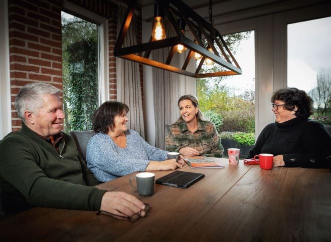 Familie rondom de eettafel met elkaar in gesprek